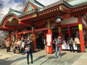 稲荷神社の境内でおみくじを引く人